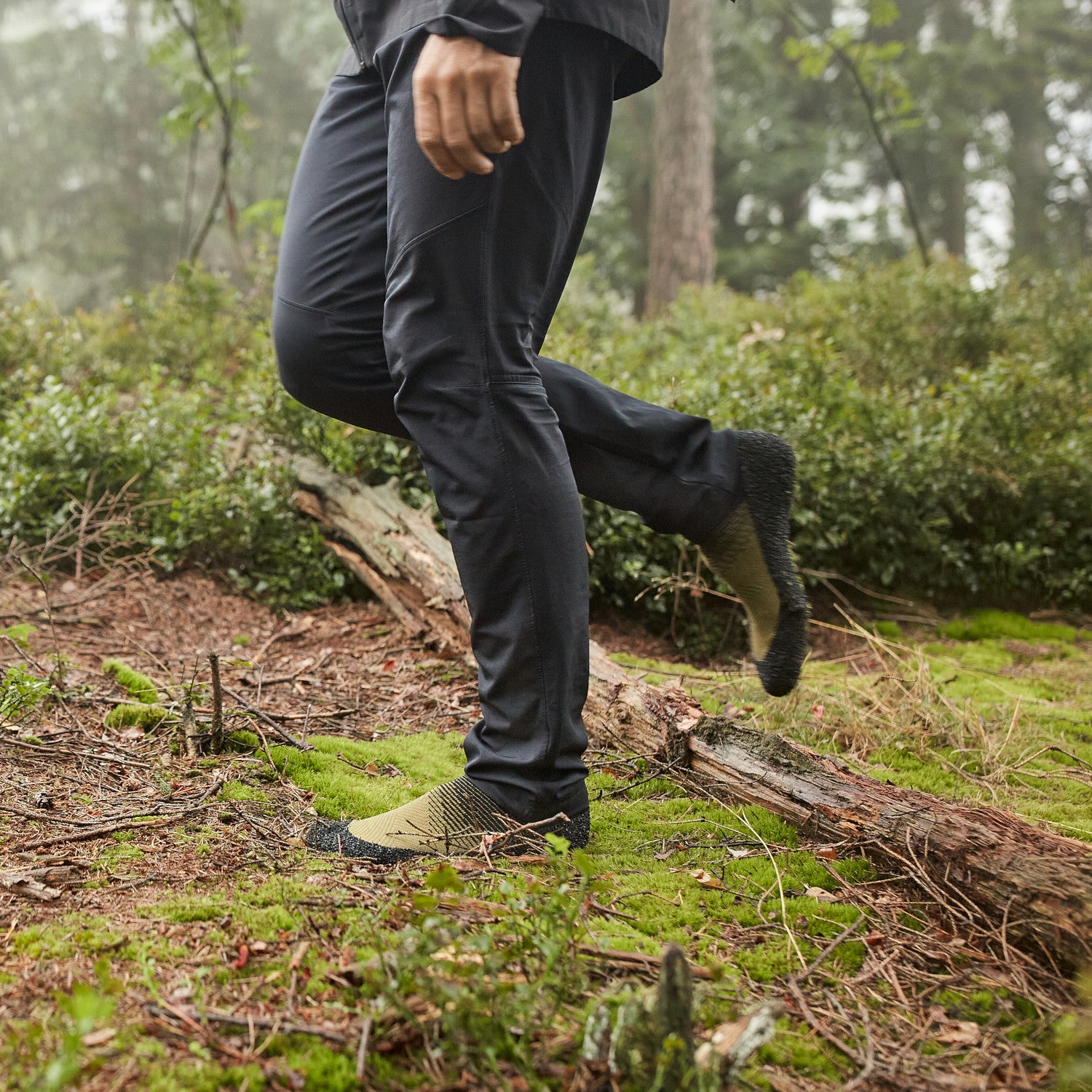 Sockenschuhe Skinners 2.0 Comfort in Moosgrün, getragen, erhältlich in unserem Onlineshop für Barfußschuhe. Das flexible Design sorgt für natürlichen Komfort und optimale Bewegungsfreiheit, ideal für sportliche Aktivitäten, Reisen und den Alltag.