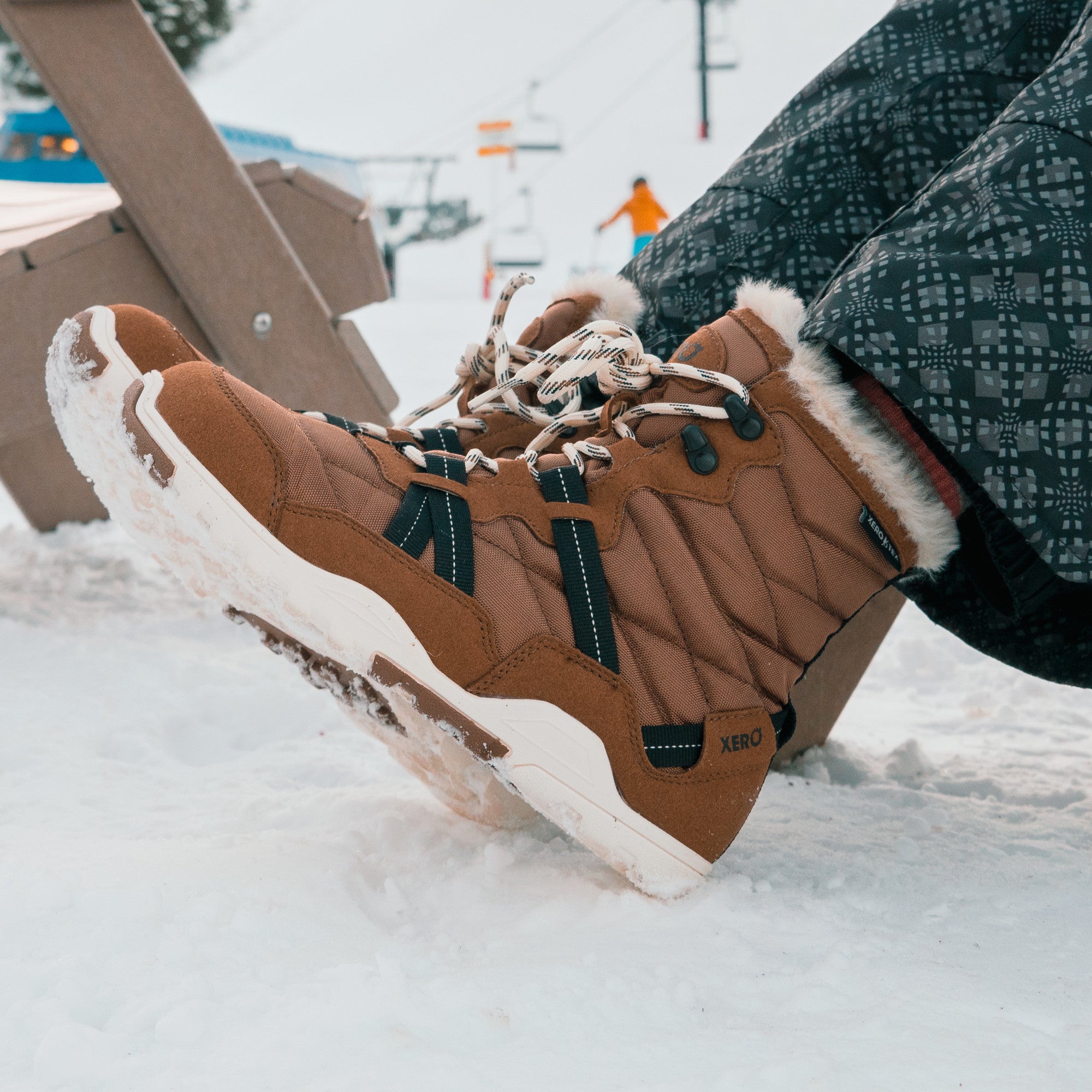 Xero Shoes Alpine Women Barfußschuhe Schneestiefel in Rubber Brown, getragen in einer Alltagsszene. Leichte, flexible Winterstiefel, die natürlichen Komfort und Wärme bieten. Erhältlich in unserem Onlineshop für Barfußschuhe.