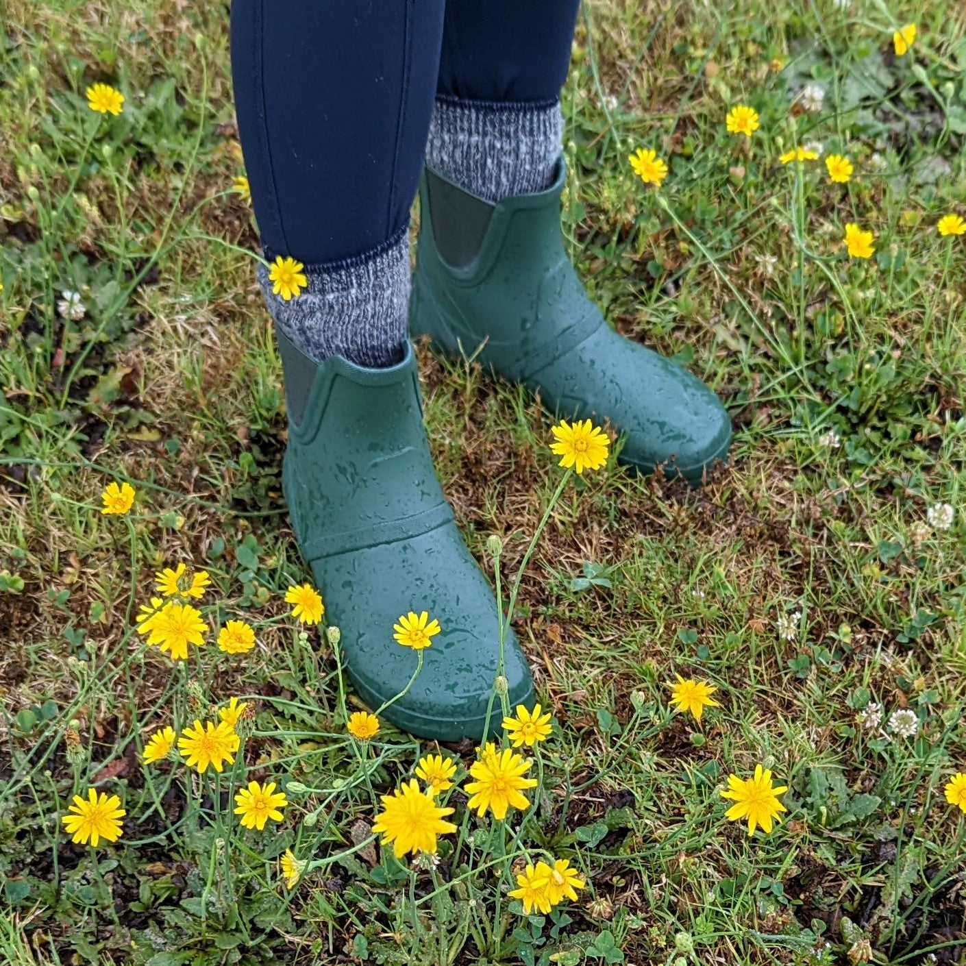 Xero Shoes Gracie Grün Damen Barfußschuhe minimalistische Regenstiefel, getragen. Diese flexiblen Regenstiefel bieten das natürliche Barfußgefühl und schützen gleichzeitig vor Nässe. Ideal für Frauen, die auch bei schlechtem Wetter nicht auf Komfort und Bewegungsfreiheit verzichten möchten. Erhältlich in unserem Onlineshop für Barfußschuhe.