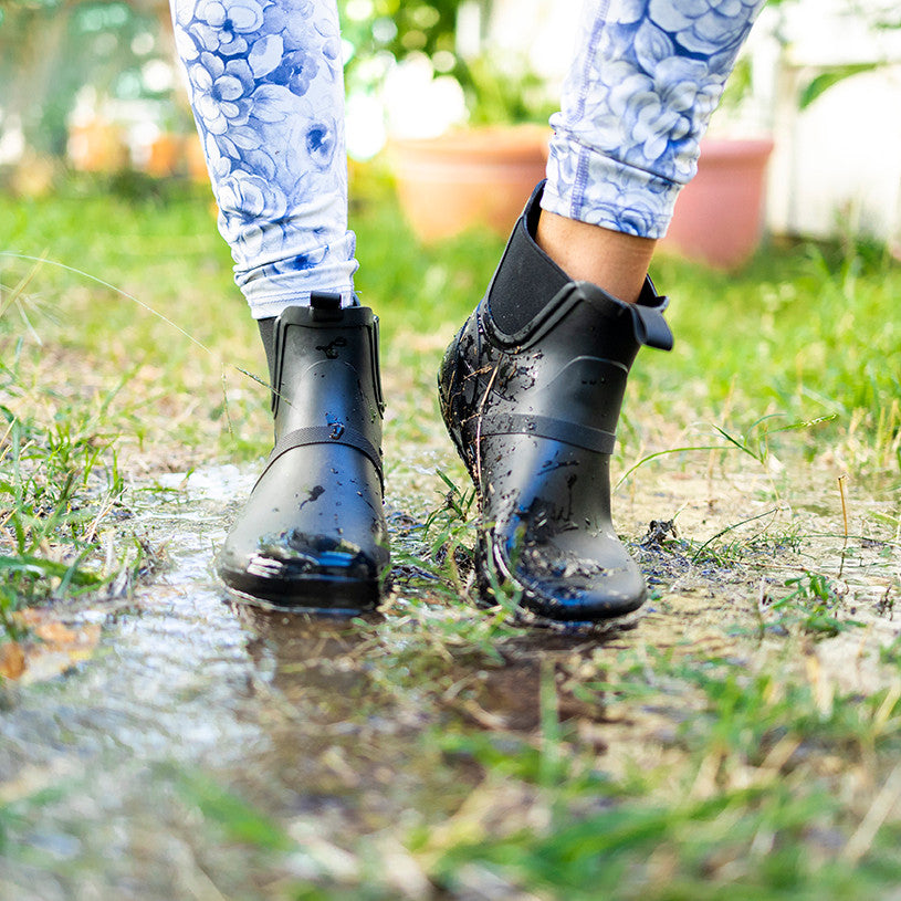 Xero Shoes Gracie Schwarz Damen Barfußschuhe minimalistische Regenstiefel, getragen. Diese Regenstiefel bieten das natürliche Barfußgefühl mit minimalistischem Design und halten Ihre Füße bei jedem Wetter trocken und komfortabel. Ideal für aktive Frauen, die bei Regenwetter nicht auf ihre Barfußschuhe verzichten möchten. Erhältlich in unserem Onlineshop für Barfußschuhe.
