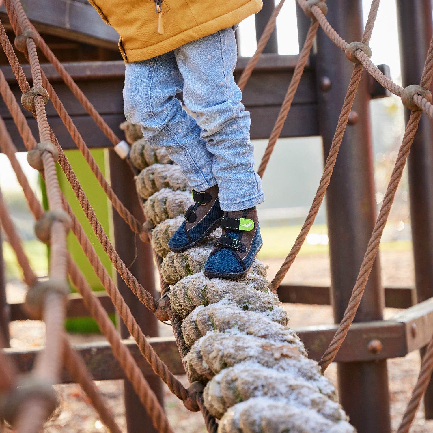 Leguanito Scippo Klett Kinder Barfußschuhe in wasserabweisender Ausführung – Ein Kind spielt fröhlich im Freien, während es die funktionalen und bequemen Barfußschuhe trägt. Die elastische Passform und der Klettverschluss sorgen für einen perfekten Sitz und viel Bewegungsfreiheit. Erhältlich bei barfusswelten.de.