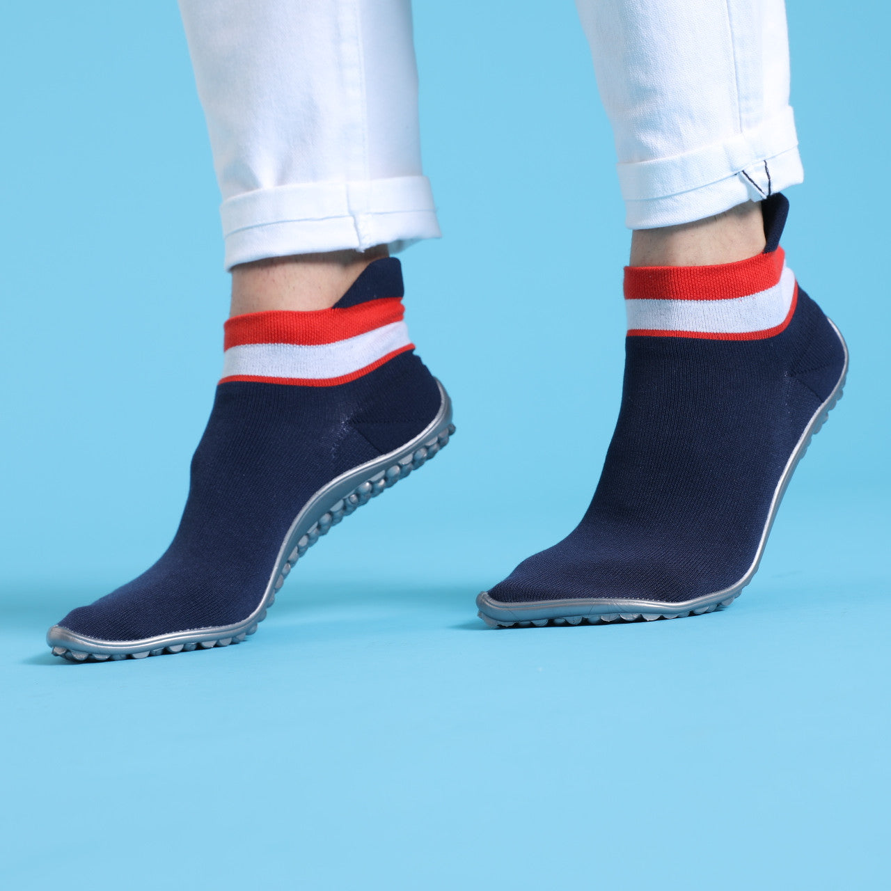 Leguano Sneaker in Blau und Rot mit weißem Bund, in Aktion gezeigt und ideal für aktives Gehen und Laufen. Jetzt erhältlich im Onlineshop für Barfußschuhe.