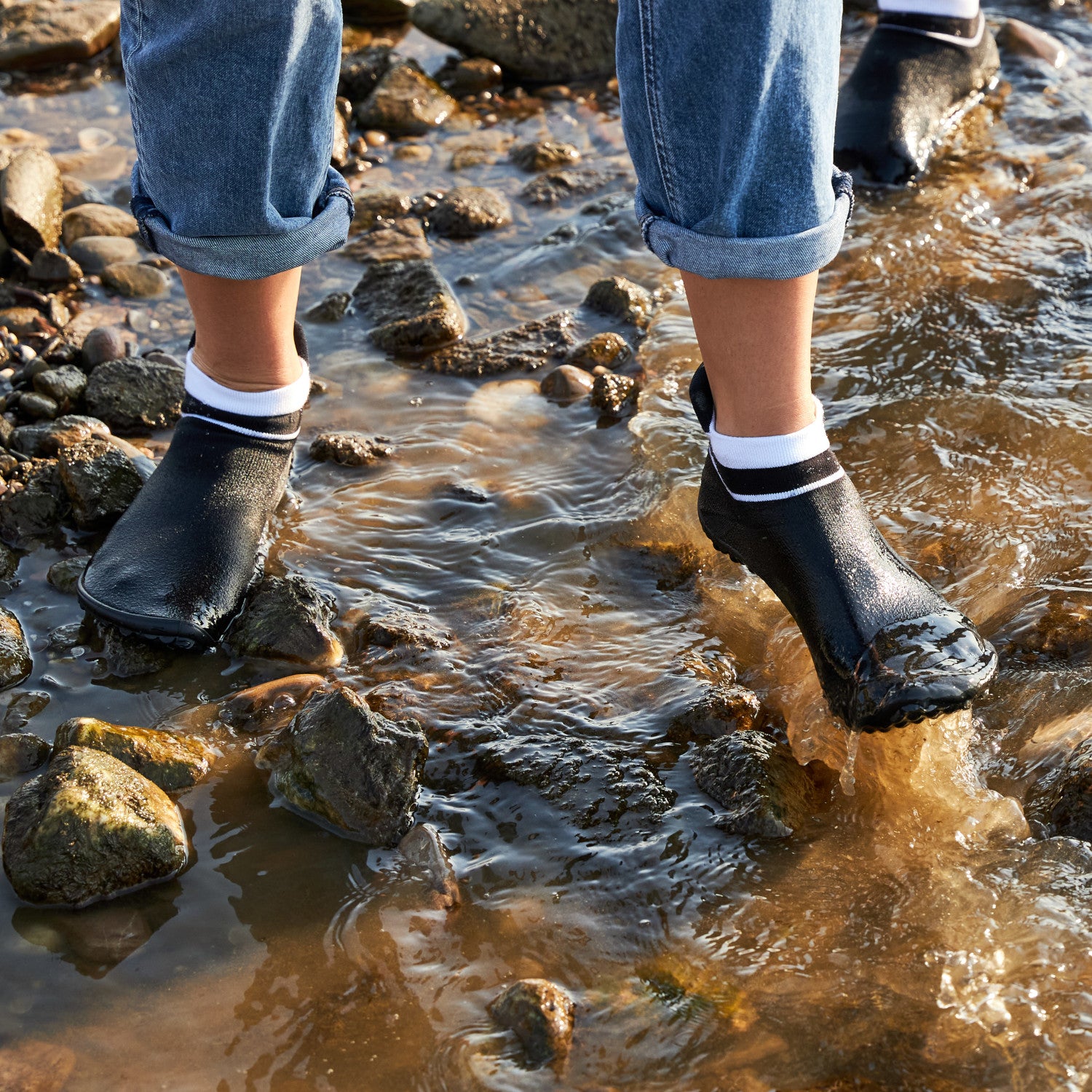Leguano Sneaker in Schwarz mit weißem Bund, in Aktion abgebildet und ideal für sportliche Aktivitäten und lässigen Alltag. Jetzt erhältlich im Onlineshop für Barfußschuhe.