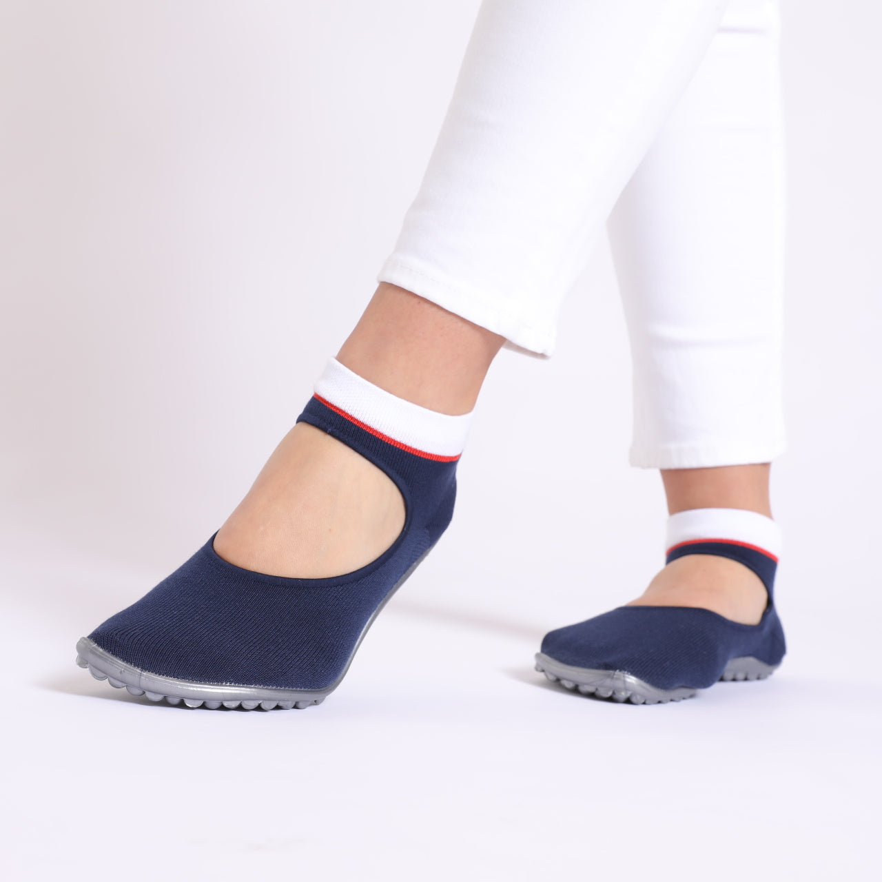 Ballerina in Blau mit rot-weißem Bund, dargestellt in einer lebhaften Alltagsszene. Diese Barfußschuhe kombinieren stilvollen Komfort mit Flexibilität und eignen sich perfekt für verschiedene Anlässe, von lässigen Ausflügen bis hin zu festlichen Veranstaltungen. Ideal für modebewusste Träger, die Wert auf Fußgesundheit legen. Jetzt im Onlineshop für Barfußschuhe erhältlich.