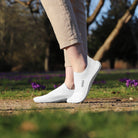 Leguano Scio Barfußslipper in Weiß, in Aktion gezeigt und ideal für minimalistisches Gehen. Jetzt erhältlich im Onlineshop für Barfußschuhe.